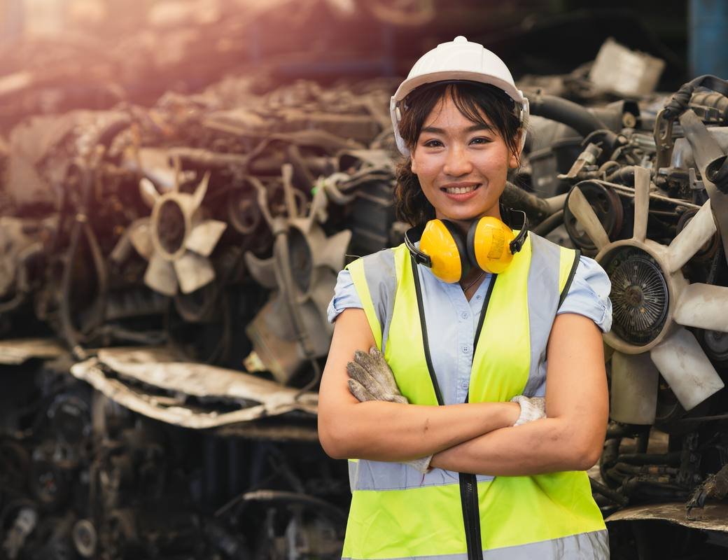 Smiling Almetco team member in safety gear at the scrap yard